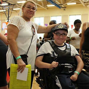 Teenager in a wheelchair with his caregiver at an ECC event